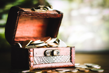 Saving money concept preset putting money coin stack growing business on bright light glowing bokeh background, business finance wealth and success concept.