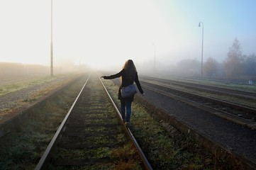 young girl walking on the train tracks