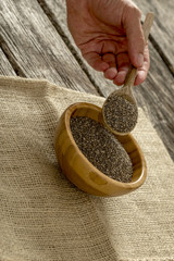 Male hand holding a wooden spoon heaping with chia seeds