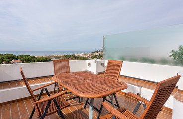 Wooden table on the terrace for relaxation outside.