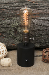 Edison lamp on wood background.