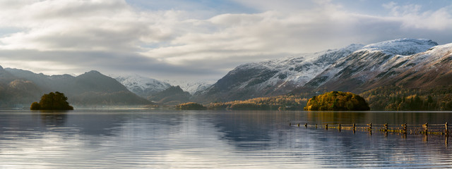 Beautiful Autumn morning at Derwentwater in the English Lake District with snowcapped mountains. - obrazy, fototapety, plakaty