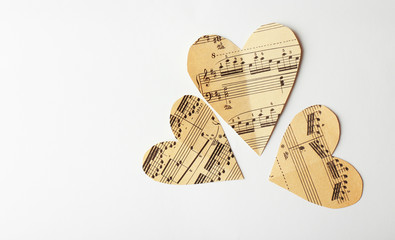 Paper hearts with notes on white background, music concept