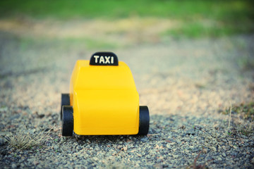 Yellow toy taxi on ground
