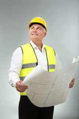 Senior experienced engineer with drawing on light background