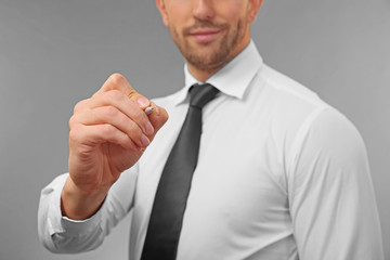 Young man writing on virtual screen, closeup
