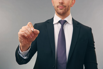 Young man writing on virtual screen, closeup