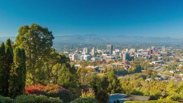 Slowly Panning Right with a Long Range View of Asheville City Downtown seen from Town Mountain during the Fall with a Blue Sky and Autumn Colored Foliage