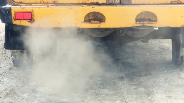 Exhaust gases from the muffler old running car in the winter.