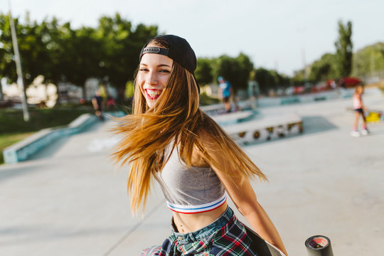 Beautiful young woman with skate in the skatepark.