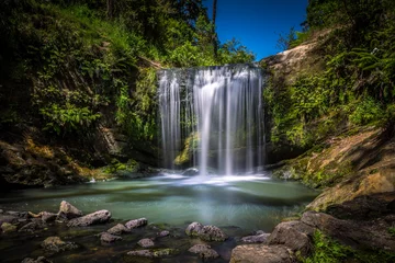 Zelfklevend Fotobehang Lange blootstelling van de Oakley Creek-waterval op een heldere zomerdag, Auckland, Nieuw-Zeeland © agcreationsnz