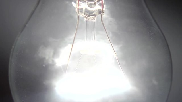 Dettaglio di una vecchia lampada al tungsteno che si accende e si spegne lentamente.