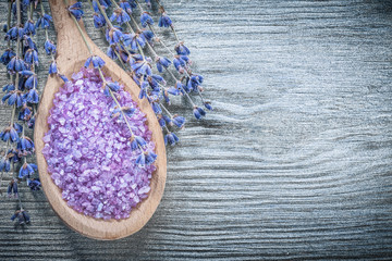 Assortment of dried lavender scented sea salt wooden spoon on wo