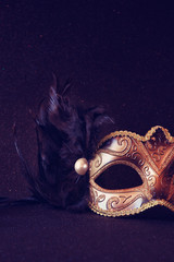 black venetian mask on glitter background