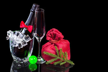 Bottle champagne in ice bucket with wineglass and gift