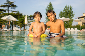 Fototapeta na wymiar Young boy kid child splashing in swimming pool having fun leisur