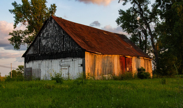 Old barn with trees at sunset