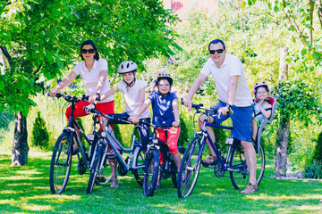 Happy family on bicycles in the park - active family concept