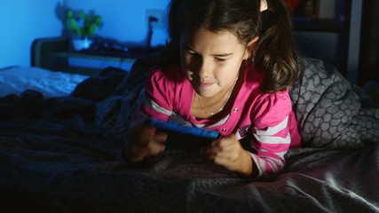 Obraz premium teen girl playing a portable video game console kid at night indoors