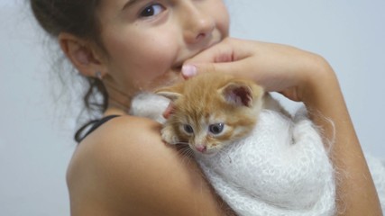 Fototapeta na wymiar girl petting a small red cat kitten holds