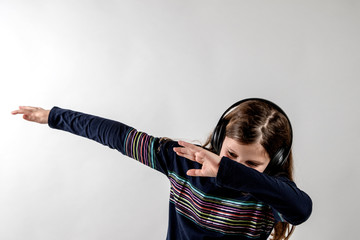 Teenage girl dabbing with headphone on with white background