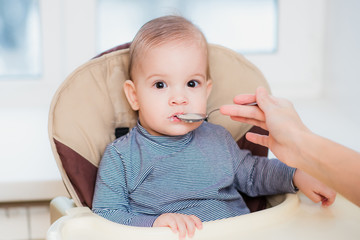 mother feeding her baby breast porridge day