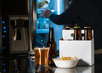 Six pack of brown beer bottles on kitchen counter