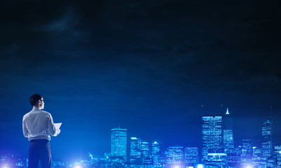 Businessman viewing night glowing city