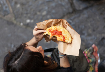 Woman photographed from above eating a pizza in Naples. - obrazy, fototapety, plakaty