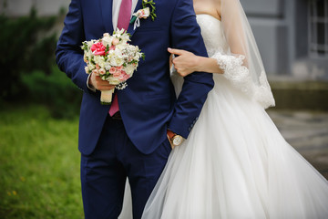 Wedding couple, bride and groom holding hands after wedding ceremony. Elegant suit, white bridal...