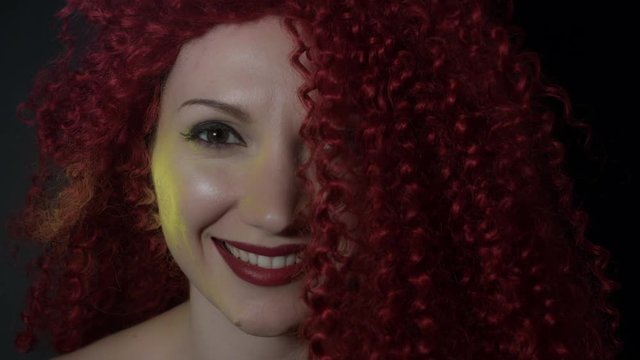 4k shoot of a redhead girl in studio with blue dust on her neck