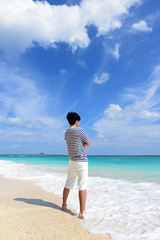 Fototapeta na wymiar 沖縄の美しいビーチで寛ぐ男性