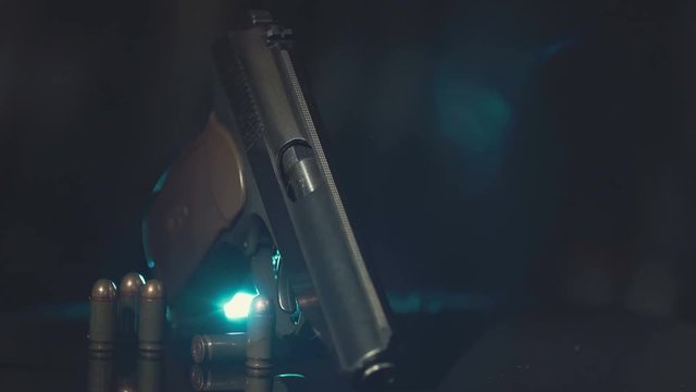 gun lies on the slowly rotating surface. Highlighted with by light.