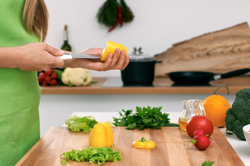 Close up of  woman's hands cooking in the kitchen. Housewife slicing ​​fresh salad. Vegetarian and healthily cooking concept