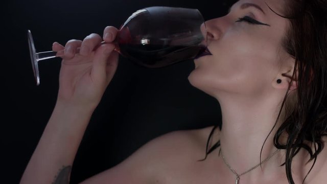 4k shoot of a horror Halloween model - Vampire drinking blood from the glass