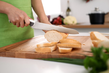 Close up of  woman's hands cooking in the kitchen. Housewife slicing ​​white bread. Vegetarian and healthily cooking concept