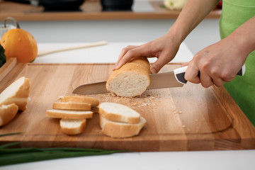 Close up of  woman's hands cooking in the kitchen. Housewife slicing ​​white bread. Vegetarian and healthily cooking concept