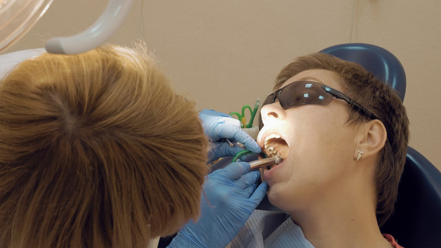 Woman at the dentist clinic office gets dental medical examination and treatment. Odontic and mouth health is important part of modern human life that dentistry help with.