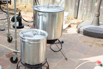 Two home brew kettles boiling wort with propane tank