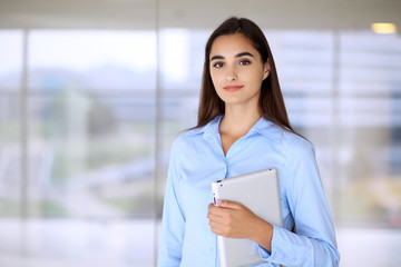 Plakat Young brunette businesswoman or student girl looking at camera