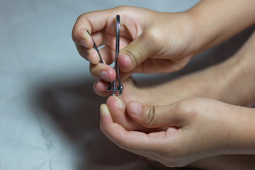 Photography closeup of a woman cutting toenails