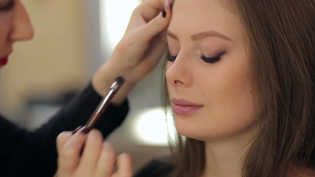 Close-up of a make-up artist applying make-up.