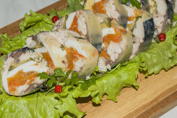 Roll of mackerel with vegetables on a wooden Board