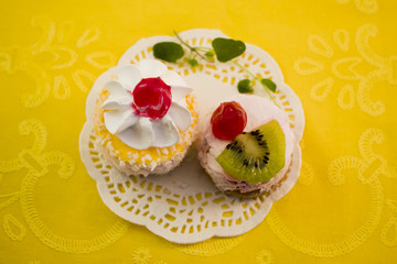 Creampuff, kiwi and cherry on a background of yellow napkins top view