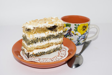 Cake with poppy seeds and almonds on a brown ceramic plate