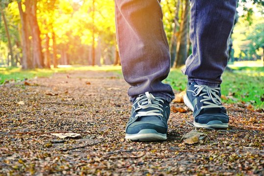 man legs walking in a park with beautiful nature spring background