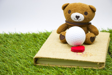 Obraz premium bear and golf ball with heart shape on diary.