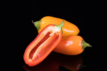 Red, yellow and orange sweet peppers isolated on black