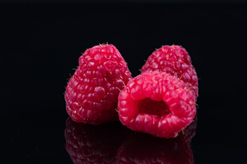 Three raspberries isolated on black