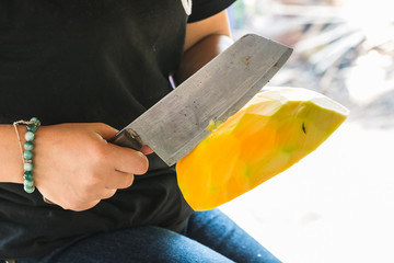 use a knife to chop papaya for cooking
